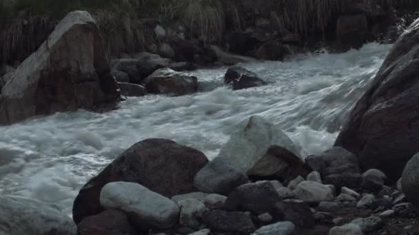 Snelle stream stroomversnellingen in hoge rocky bergen bedekt met sneeuw met groene struiken — Stockvideo