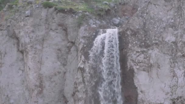 Cascada fluye hacia abajo sobre acantilado rocoso en las montañas — Vídeos de Stock