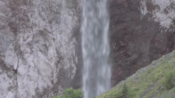 Cascade d'eau coulant sur une falaise rocheuse dans les montagnes 