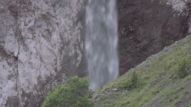 La cascade d'eau descend sur une falaise rocheuse dans les montagnes 