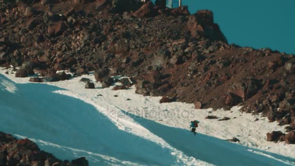 Senderista camina en el pico de la montaña cubierto de nieve con bastones — Vídeo de stock