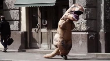 Saint Petersburg, Rusya - 1 Nisan 2017: Komik adam t rex kostüm şehir kaldırımda yürüyen insanlar kalabalık içinde
