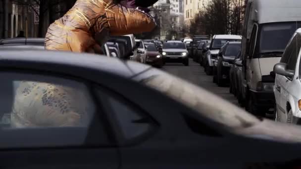 Санкт-Петербург, Російська Федерація - 1 квітня 2017: Людина в динозавра костюм жартівник працює на вулиці міста пішохідний перехід — стокове відео