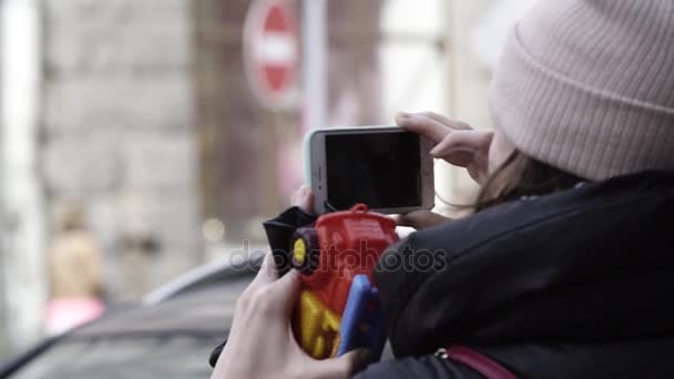 Saint Petersburg, Oroszország - 2017. április 1.: A nő utcai figyelembe képet smartphone gazdaság játék teherautó — Stock videók