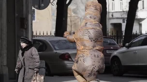 SAINT PETERSBURG, RUSSIA - APRIL 1, 2017: Prankster in t rex costume in crowd of people running on city sidewalk — Stock Video