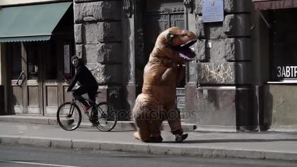 SAINT PETERSBURG, RÚSSIA - 1 de abril de 2017: Homem engraçado em traje de dino na multidão de pessoas andando na calçada da cidade — Vídeo de Stock