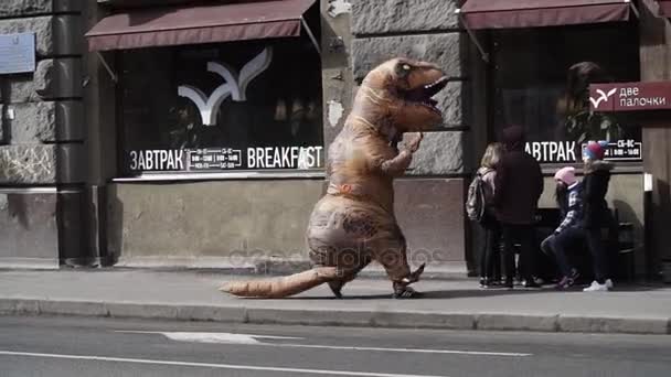 Санкт-Петербург, Російська Федерація - 1 квітня 2017: Людина в динозавра костюм жартівник працює перед кафе — стокове відео