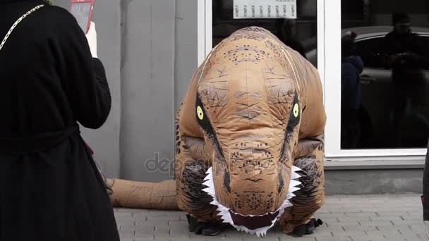 Sint-Petersburg, Rusland - 1 April 2017: Persoon in dinosaurus mascotte kostuum crouching en dansen op de stoep — Stockvideo