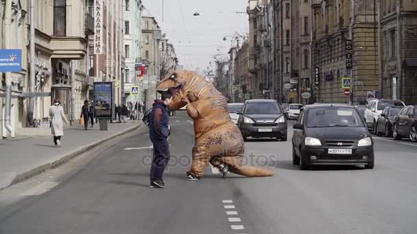 Санкт-Петербург, Російська Федерація - 1 квітня 2017: Pranker в t рекс костюм працює на вулиці міста пішохідний перехід — стокове відео