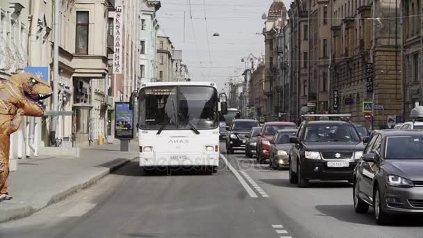 SAINT PETERSBURG, RÚSSIA - ABRIL 1, 2017: Pessoa em t rex figurino brincadeira andando na rua da cidade passadeira — Vídeo de Stock