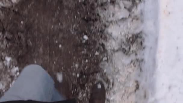 Homem POV em botas escuras andando na estrada suja no inverno — Vídeo de Stock