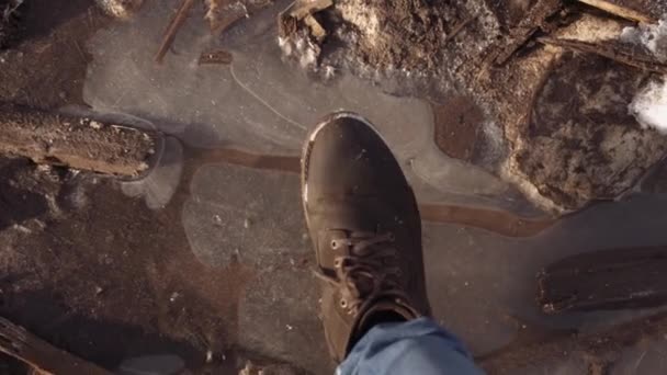 Muž nohy v boot přestávek ledu na špinavé kaluži POV — Stock video