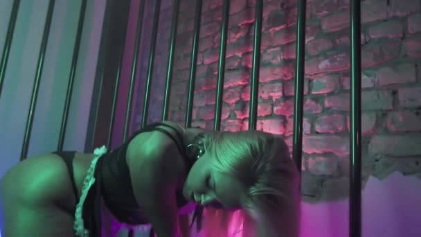 Zinnelijke jonge lang haar blond in zwarte lingerie verleidelijke beweegt in metalen kooi — Stockvideo