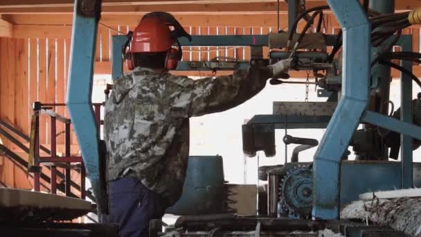 Möbelsnickare i hjälm styckning trä block på industriella såg workbench — Stockvideo
