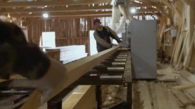 Ağaç kereste fabrikası, arıtıcı makinede ahşap tahta koyar