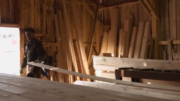 Workers pick up board running out carpenter jointer machine at woodwork facility — Stock Video