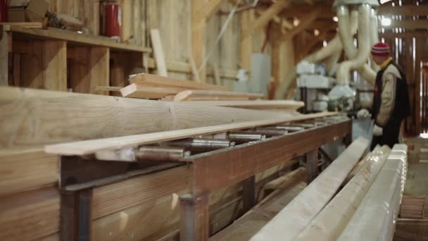 Los trabajadores recogen tablón que se ejecuta la máquina de carpintería en la fábrica de aserraderos — Vídeos de Stock