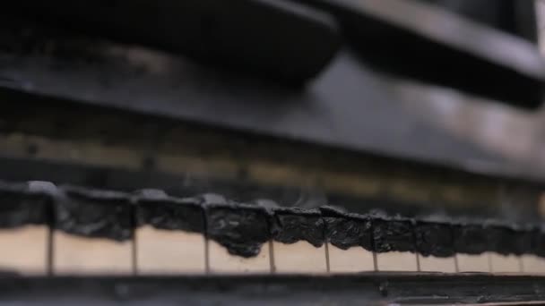 Quemado hasta el teclado de piano negro humeante — Vídeos de Stock