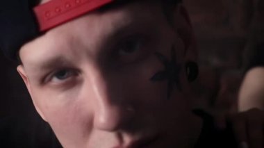 Genç kızlarla snapback tuğla duvar önünde yüz dövmeli adam cool