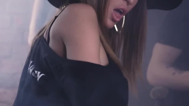 Sexy mladá žena v klobouku lákavé pohyby v temné místnosti, červená cihlová zeď — Stock video