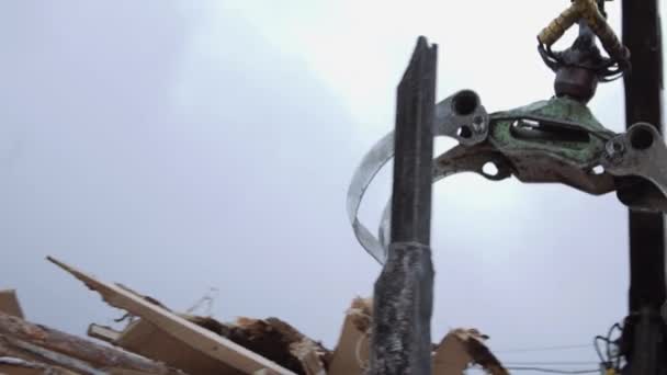 Механічний навантажувач розвантажує обрізки деревини з важкої вантажівки при виробництві лісопильних заводів — стокове відео