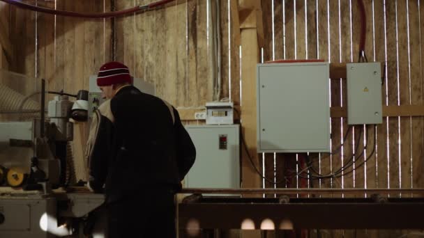 Joiners coloca prancha de madeira na máquina de refinaria na serraria — Vídeo de Stock