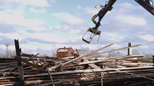 Механический погрузчик когтей выгружает объедки древесины, тяжелый грузовик на лесопилке — стоковое видео