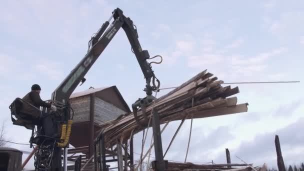 Heavy claw loader unloads timber scraps from heavy truck at sawmill facility — Stock Video