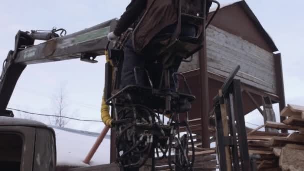 Vrachtwagen klauw loader verwijderd kladjes van hout uit zware vrachtwagen bij de zagerij faciliteit — Stockvideo