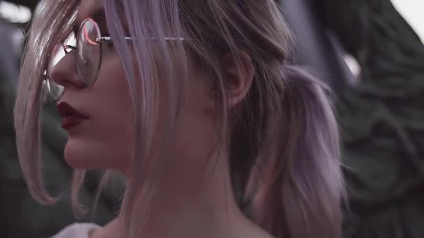 Krásná mladá dívka s ohon v kulaté brýle v amusment parku — Stock video