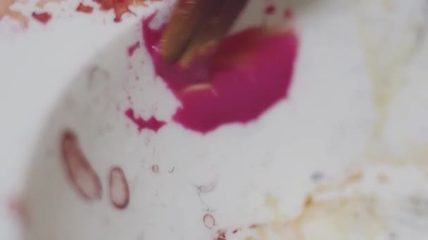 Pennello sbavature vernice di colore rosa brillante su tavolozza di plastica bianca — Video Stock