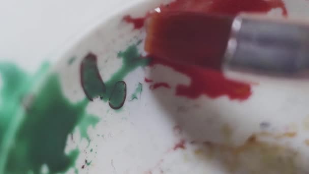 Pennello miscelazione acquerello verde e rosso su plastica bianca tavolozza sporca — Video Stock