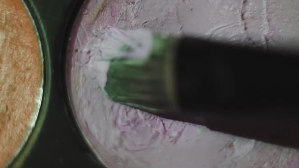 Пензлик розмиває світло-рожеву фарбу в коробці для фарби — стокове відео