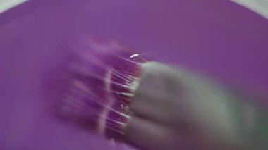 Boya fırçası ile mor renk boya su cam içine dalma