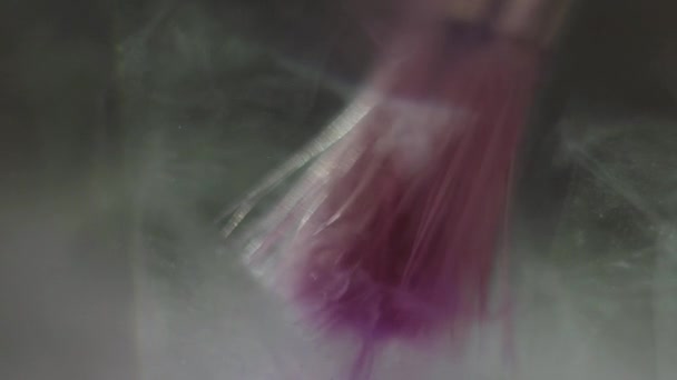 美丽的紫色颜料 cloudd 漂浮在液体中的刷子 — 图库视频影像
