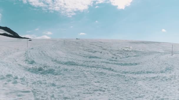 Aerial shot of mountain slope covered in snow and tracks — Stock Video