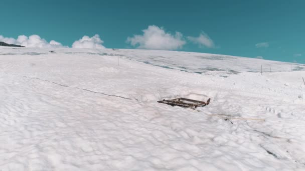 Aerial shot of mountain sidehill covered in snow and tracks — Stock Video