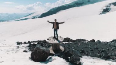 Havadan çekim adam kablo biriktirme karlı dağlarda taş üzerinde duran silah yükselir