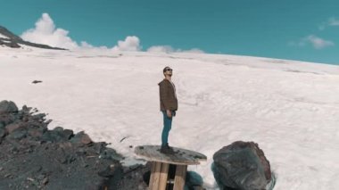 Havadan görünümü adam kablo biriktirme buzlu dağ tepe, ayakta tezahürat