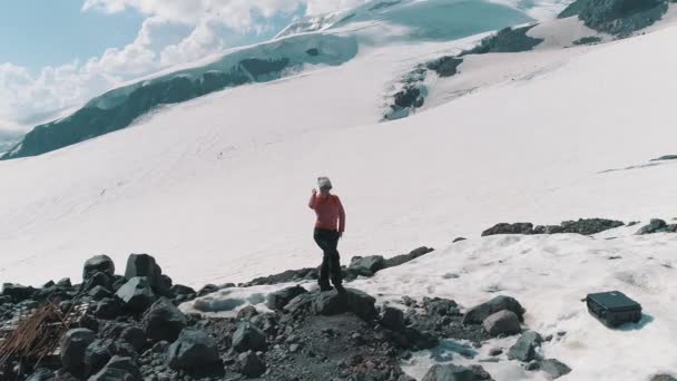 Mujer tiro aéreo bailando sobre rocas en las montañas nevadas paisaje pintoresco — Vídeo de stock