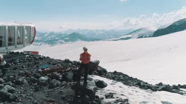 Luchtfoto vrouw dansen op de rotsen bij besneeuwde bergen mooi landschap — Stockvideo