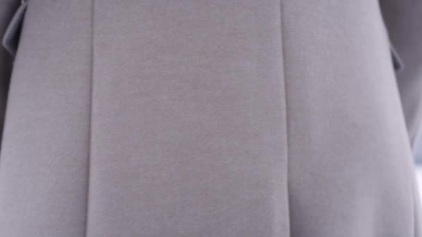 Unerkennbarer männlicher Taillenspiegel in braunem Mantel dreht sich um und steckt Hand in Tasche — Stockvideo