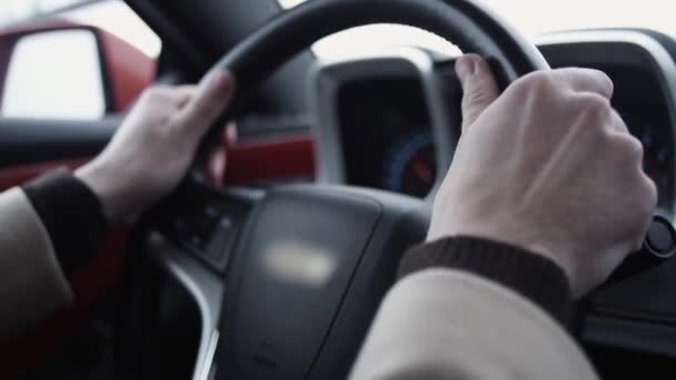 Мужские руки на рулевом колесе за рулем дорогого автомобиля в светлый день — стоковое видео