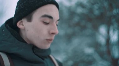 Ormandaki mesafe içine sıcak giysiler içindeki genç adam görünüyor