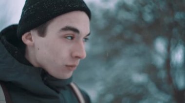 Ormandaki mesafe içine sıcak giysiler içinde genç adam görünüyor