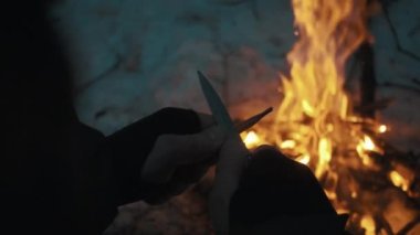 Erkek el sustalı bıçak kamp ateşi üzerine kalem keskinleştirir