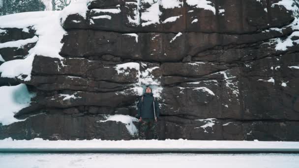 Jovem meditando na frente da parede da montanha de pedra coberta de neve — Vídeo de Stock