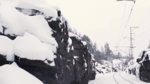 Góry skaliste, pokryte śniegiem, w pobliżu drogi kolejowe — Wideo stockowe