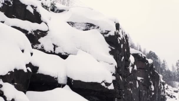 Rocky cliff covered in snow near railway road — Stock Video