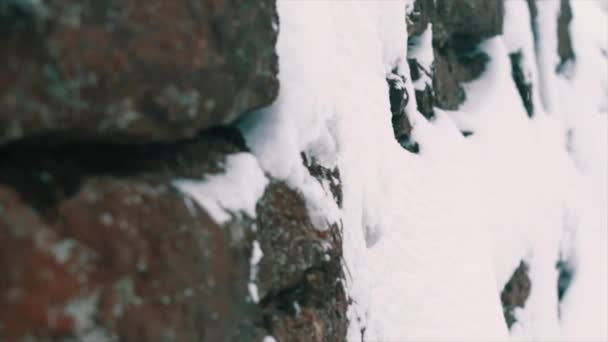 Parede de pedra de penhasco de montanha coberto de neve no dia de inverno — Vídeo de Stock
